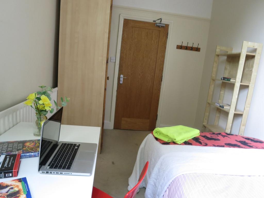 A cozy student bedroom featuring a neatly made ...