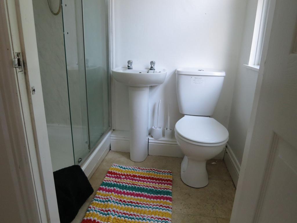 Clean and bright bathroom featuring a shower wi...