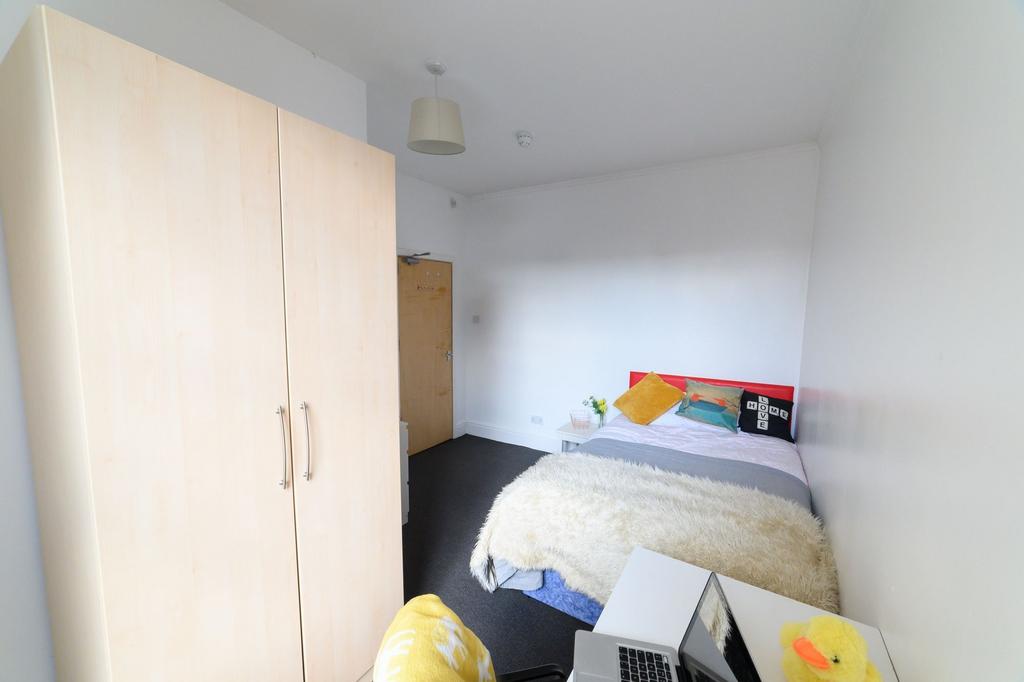 A cozy bedroom featuring a double bed with colo...