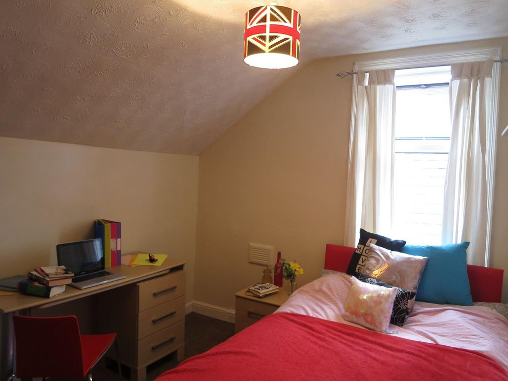 A bright and cozy bedroom featuring a large win...