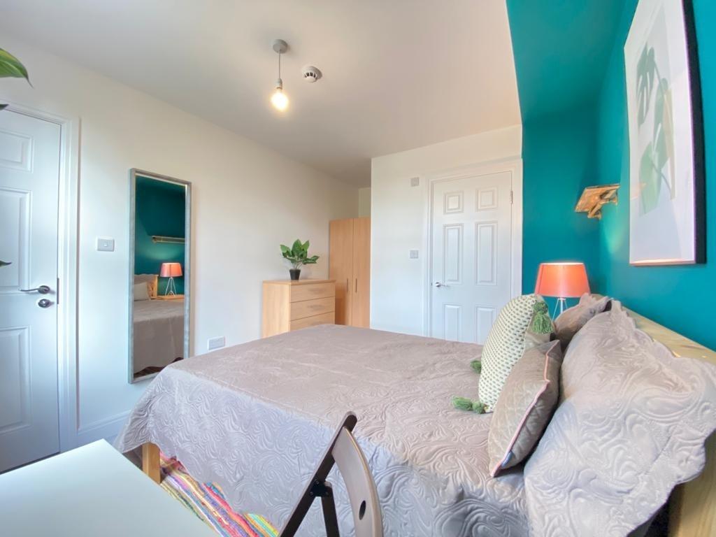 A cozy, well-lit bedroom featuring a comfortabl...