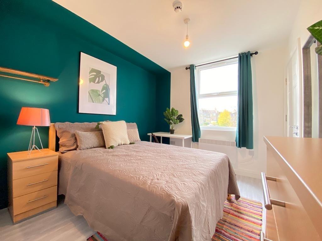 Bright and welcoming double bedroom featuring a...