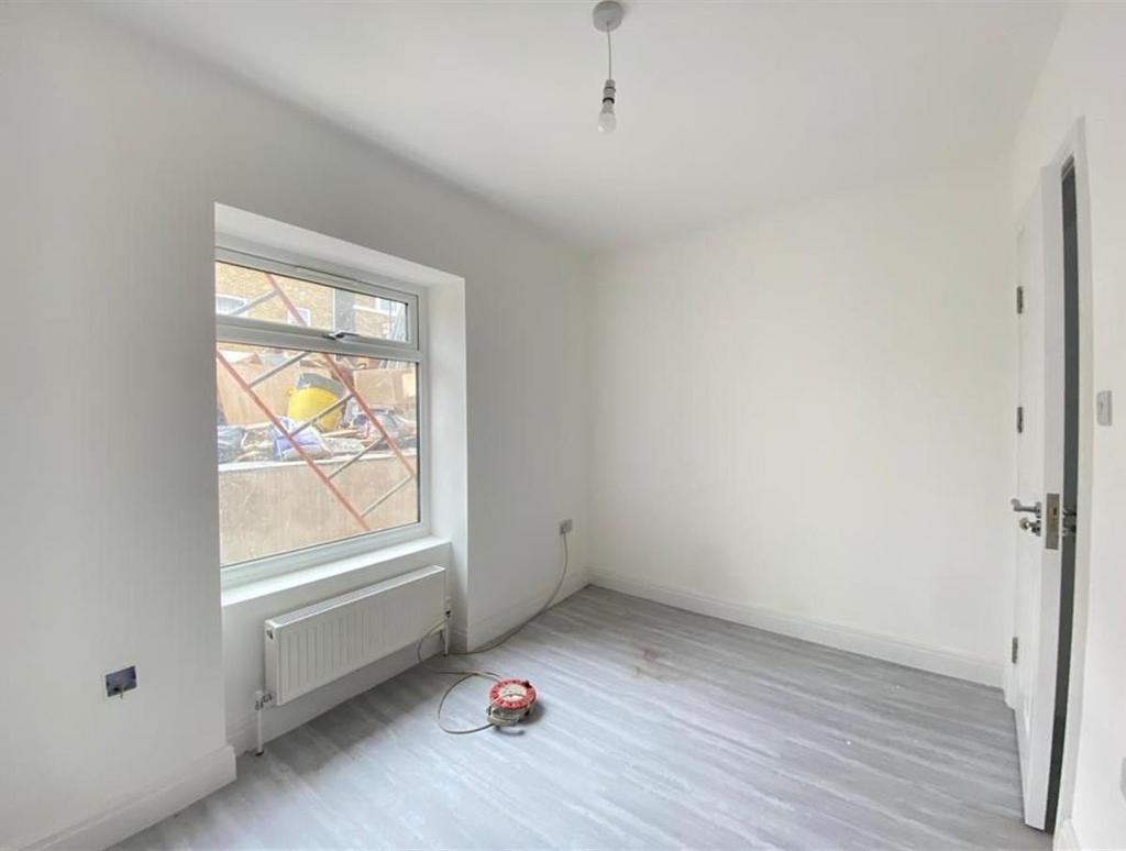 A bright, empty bedroom with freshly painted wh...