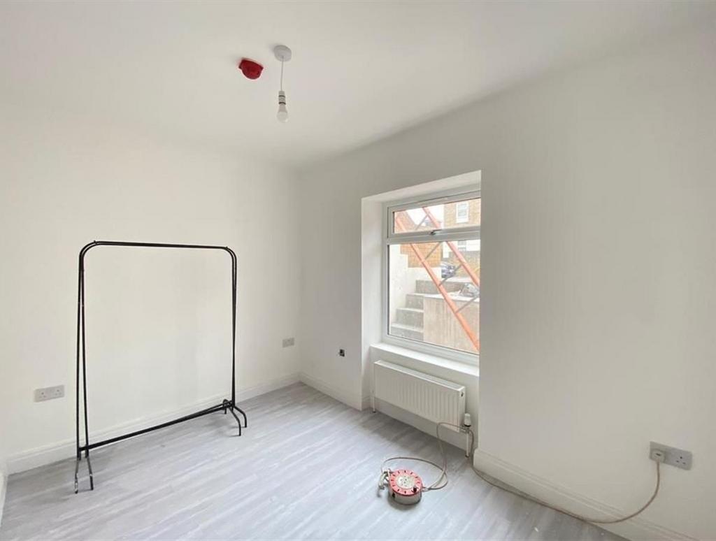 A bright, empty bedroom with white walls and a ...