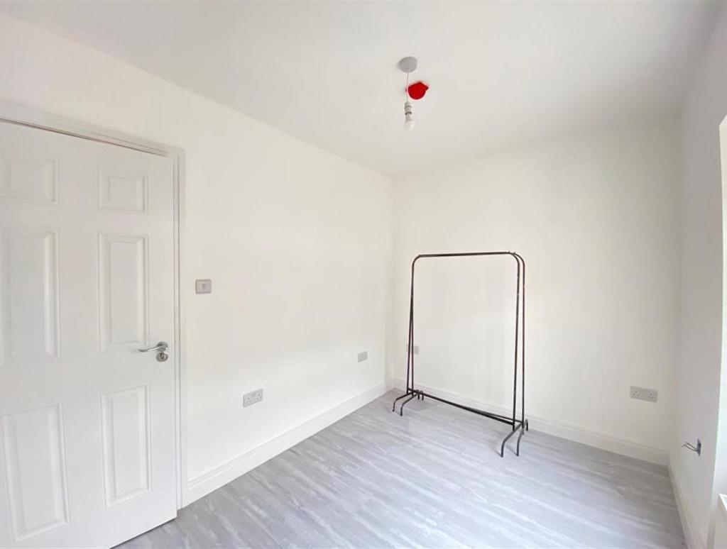 A bright and clean bedroom with white walls and...