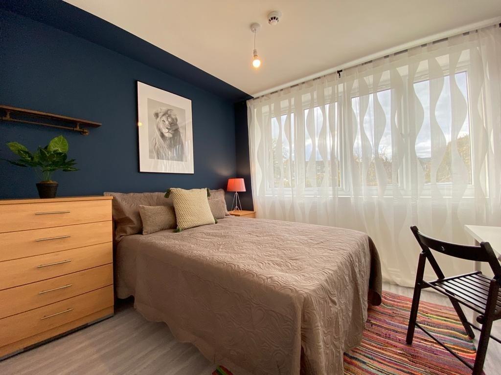 A cozy and well-lit double bedroom featuring a ...