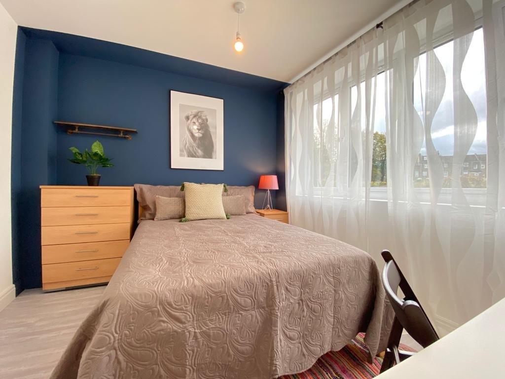 Bright and welcoming double bedroom featuring a...