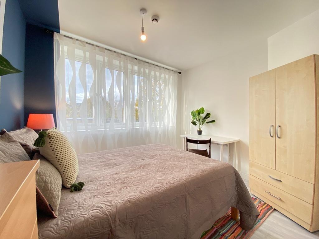 Bright and welcoming double bedroom featuring a...