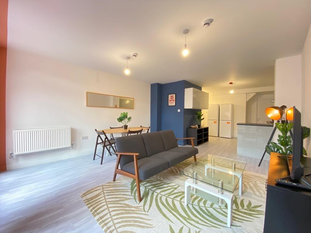 A spacious, modern living room illuminated with...