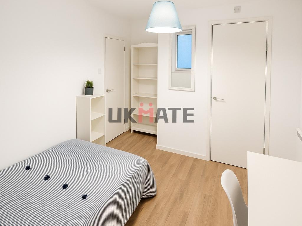 A bright and tidy bedroom with a comfortable be...