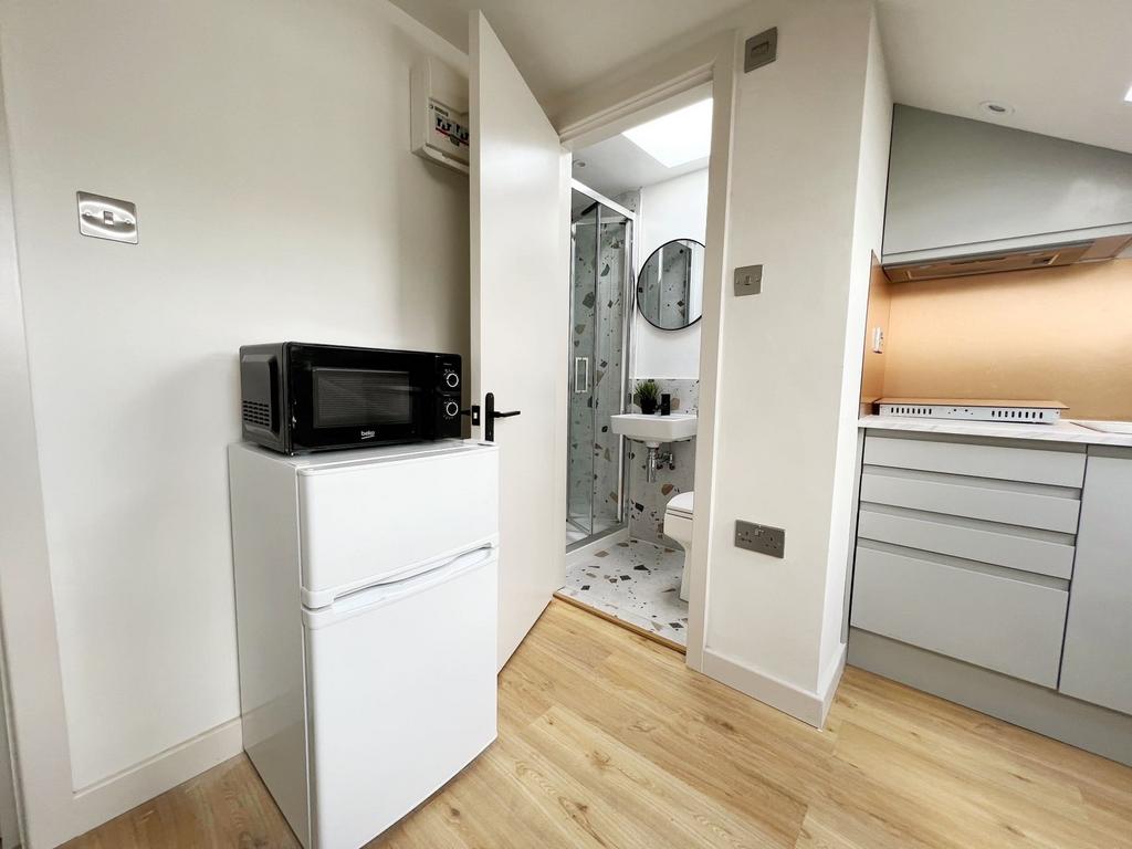 Modern kitchen with compact appliances and ligh...