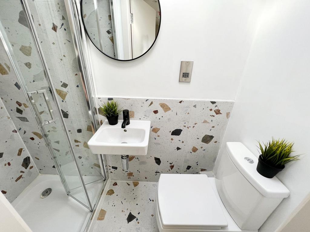 A modern bathroom with a white toilet and a sma...
