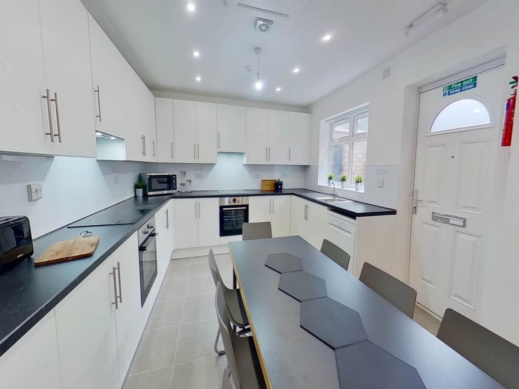 A modern, well-lit kitchen with sleek white cab...