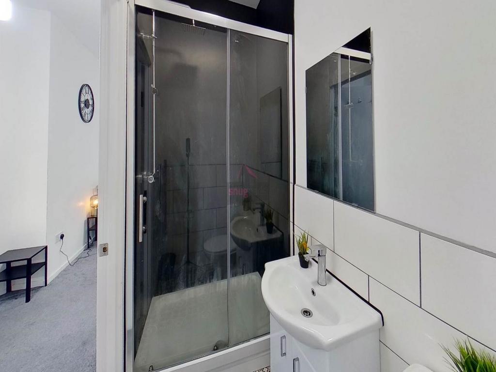 A clean and functional bathroom featuring a sho...