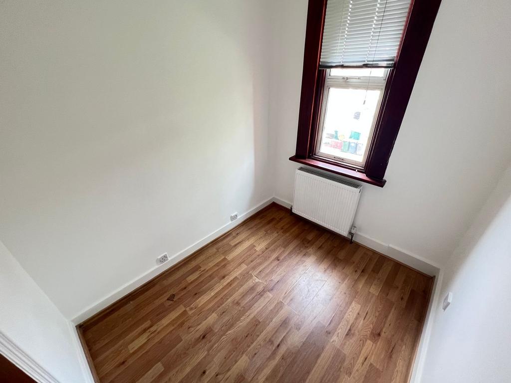 A bright single bedroom featuring wood laminate...