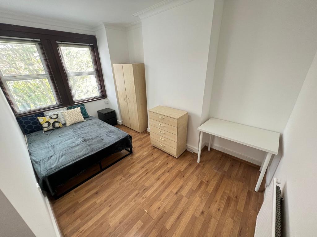 A bright and tidy double bedroom featuring larg...