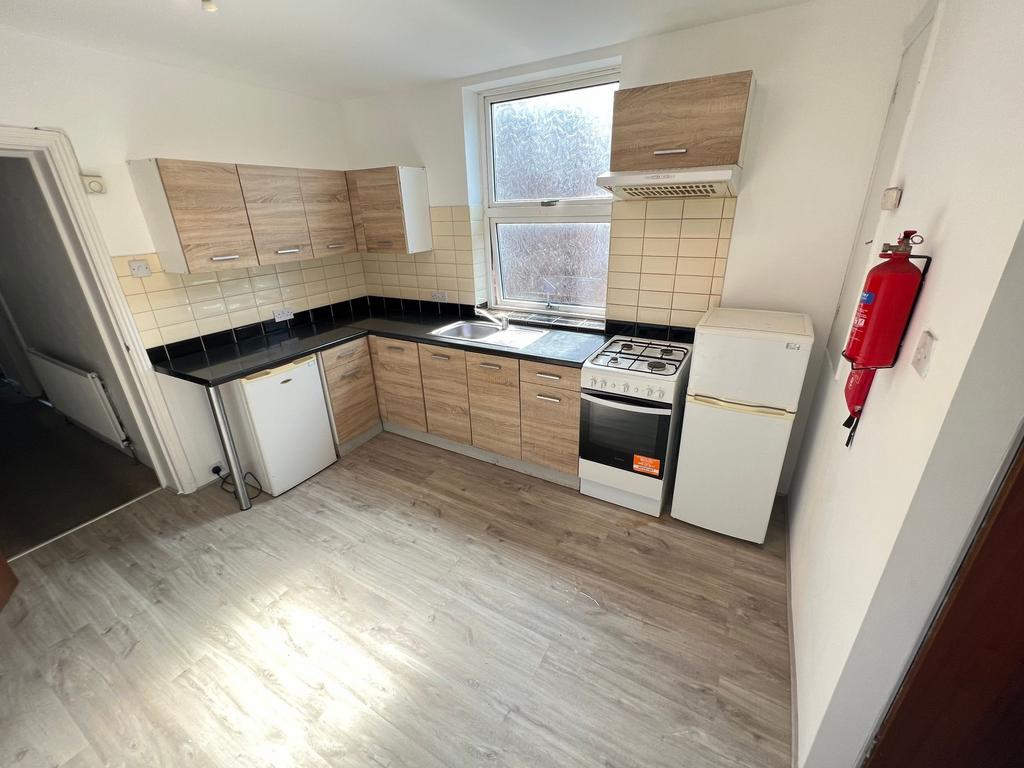 A modern kitchen featuring light wood cabinets,...