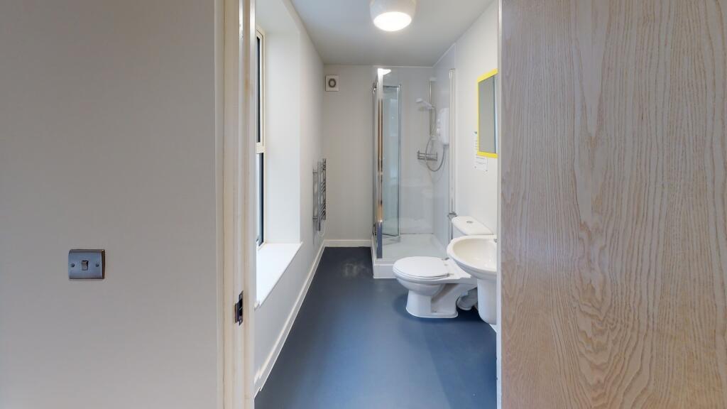 Bright and clean bathroom with white fixtures a...