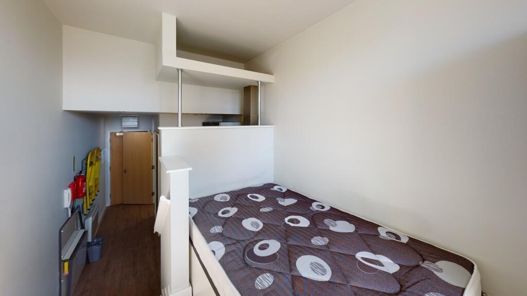 A neat and functional single bedroom featuring ...