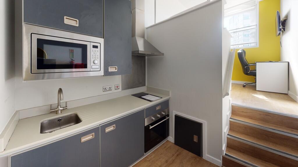 A modern, compact kitchen area featuring sleek ...
