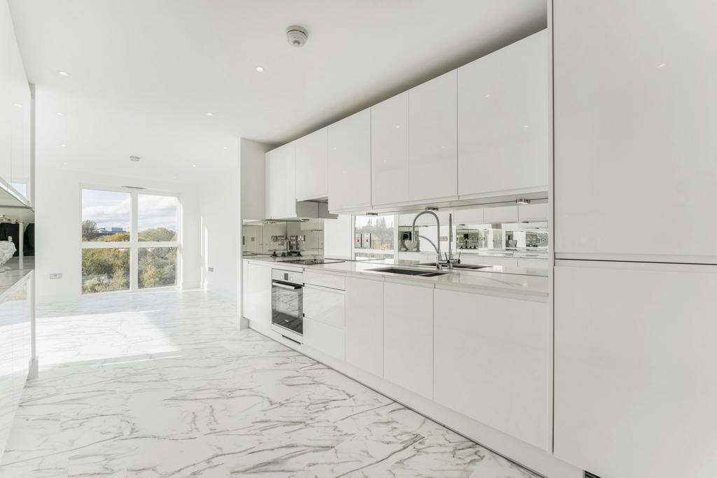 Bright and modern kitchen with sleek white cabi...