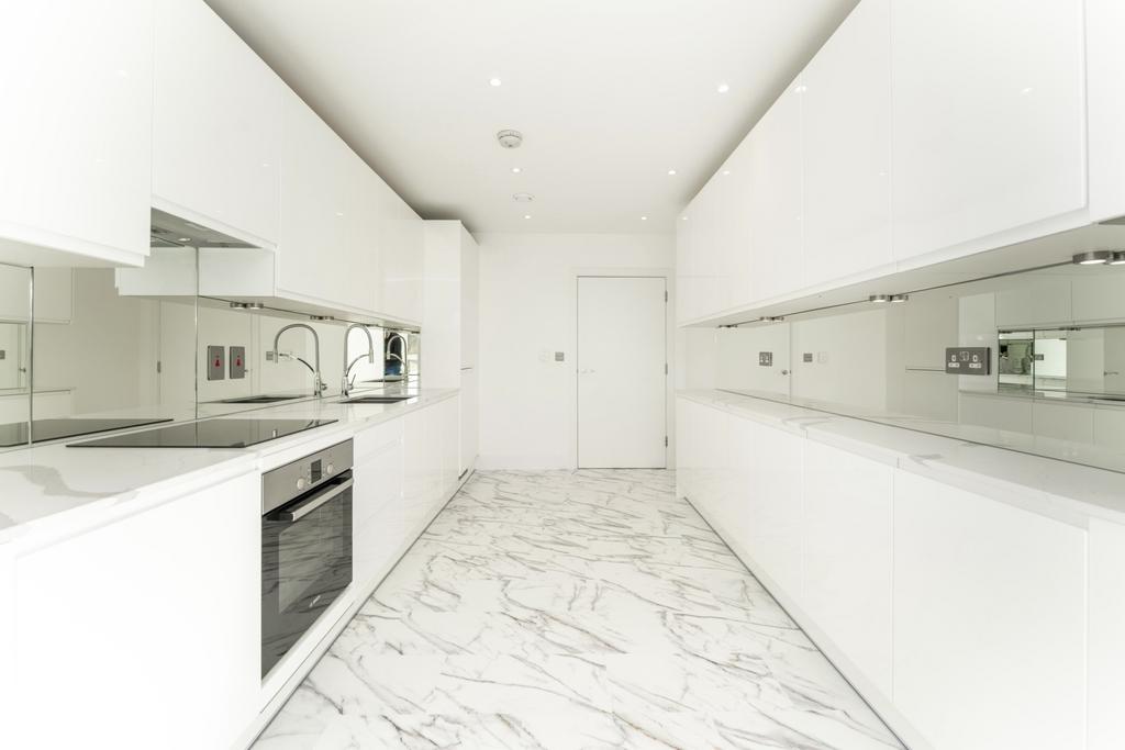 A sleek, modern kitchen featuring glossy white ...