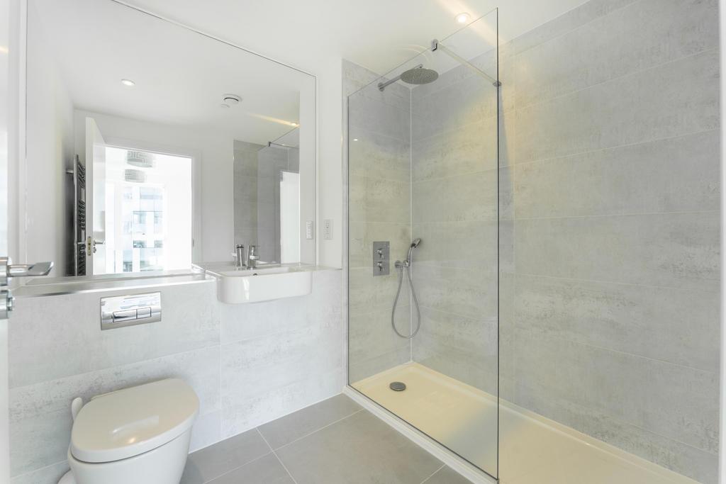 A modern bathroom featuring a spacious walk-in ...