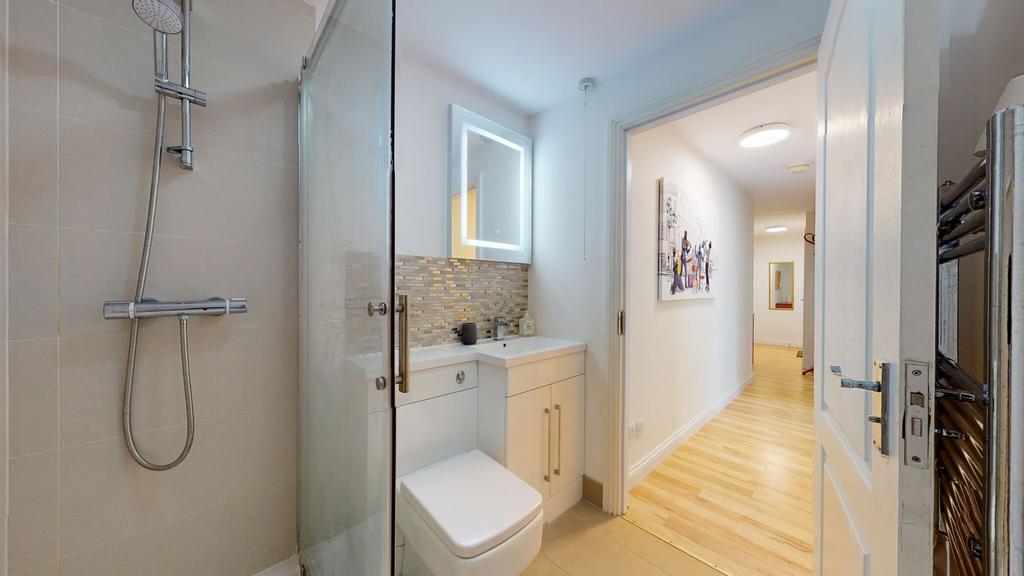 Modern bathroom featuring a sleek shower, a con...