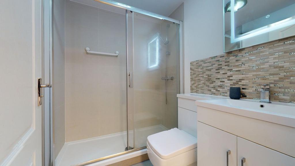 Modern bathroom featuring a spacious shower enc...