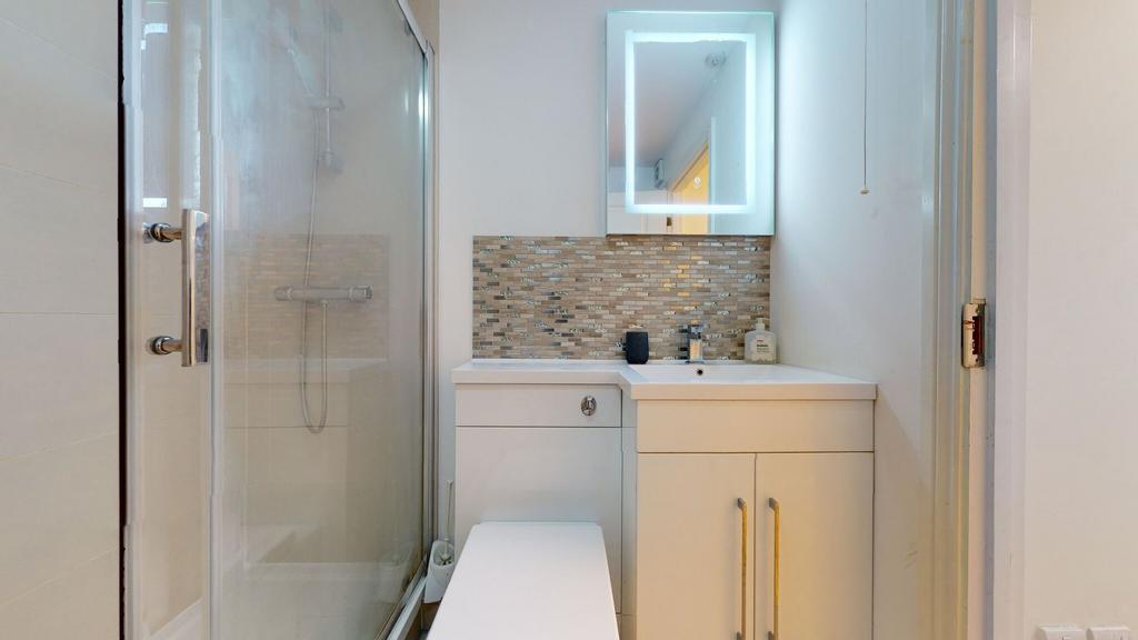 Modern bathroom featuring a glass-enclosed show...