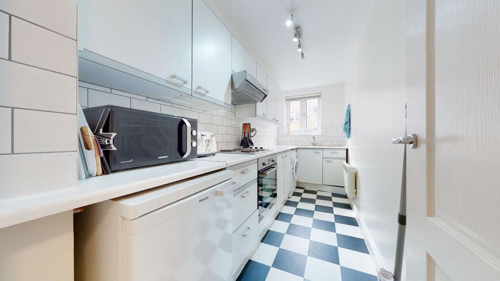 Bright and tidy kitchen with modern white cabin...