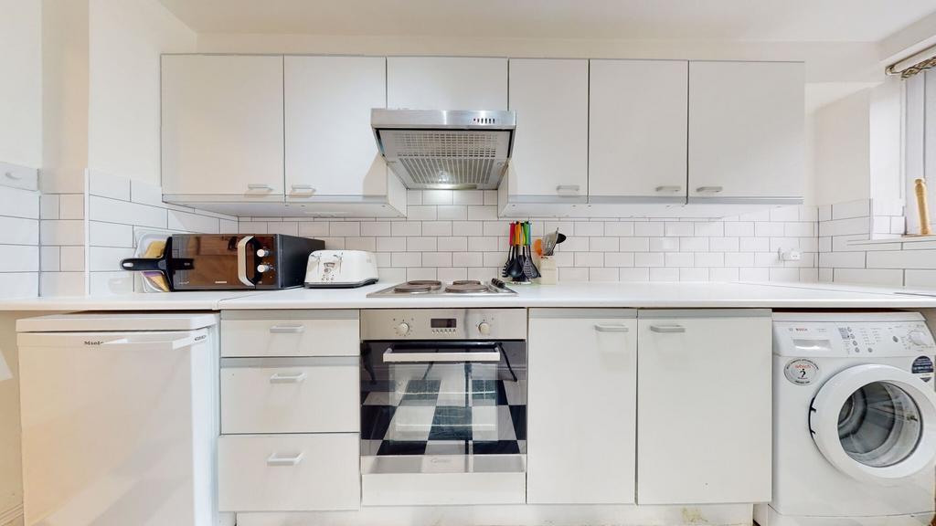 Bright and modern kitchen featuring white cabin...