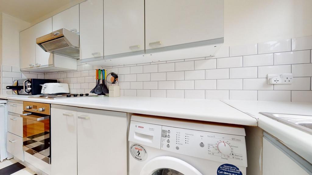 Bright and clean kitchen featuring white cabine...