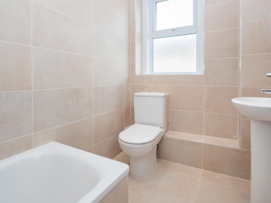 A bright and pristine bathroom featuring a whit...