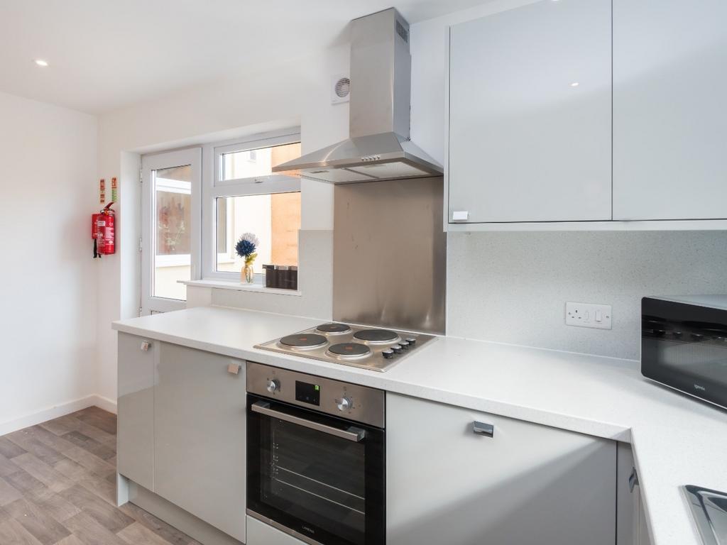 Modern fitted kitchen with clean white units...