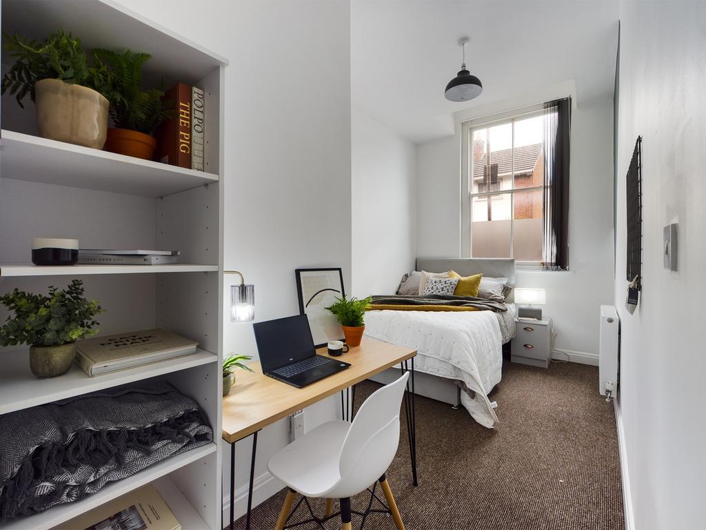 A bright and inviting double bedroom with a stu...