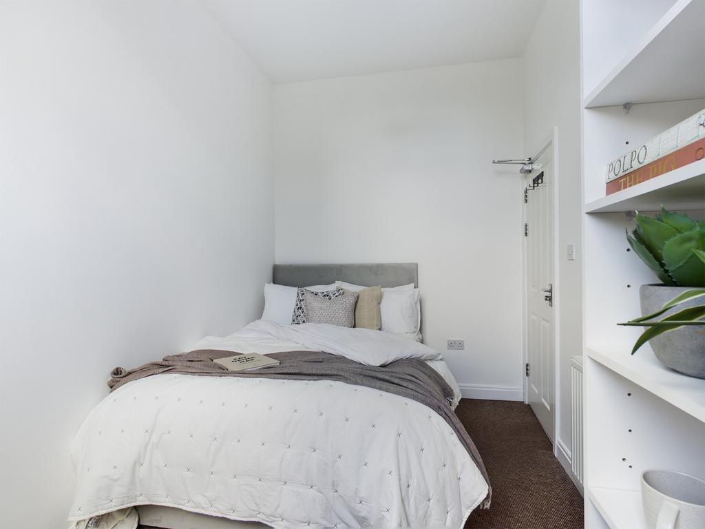 A bright and inviting double bedroom with a coz...