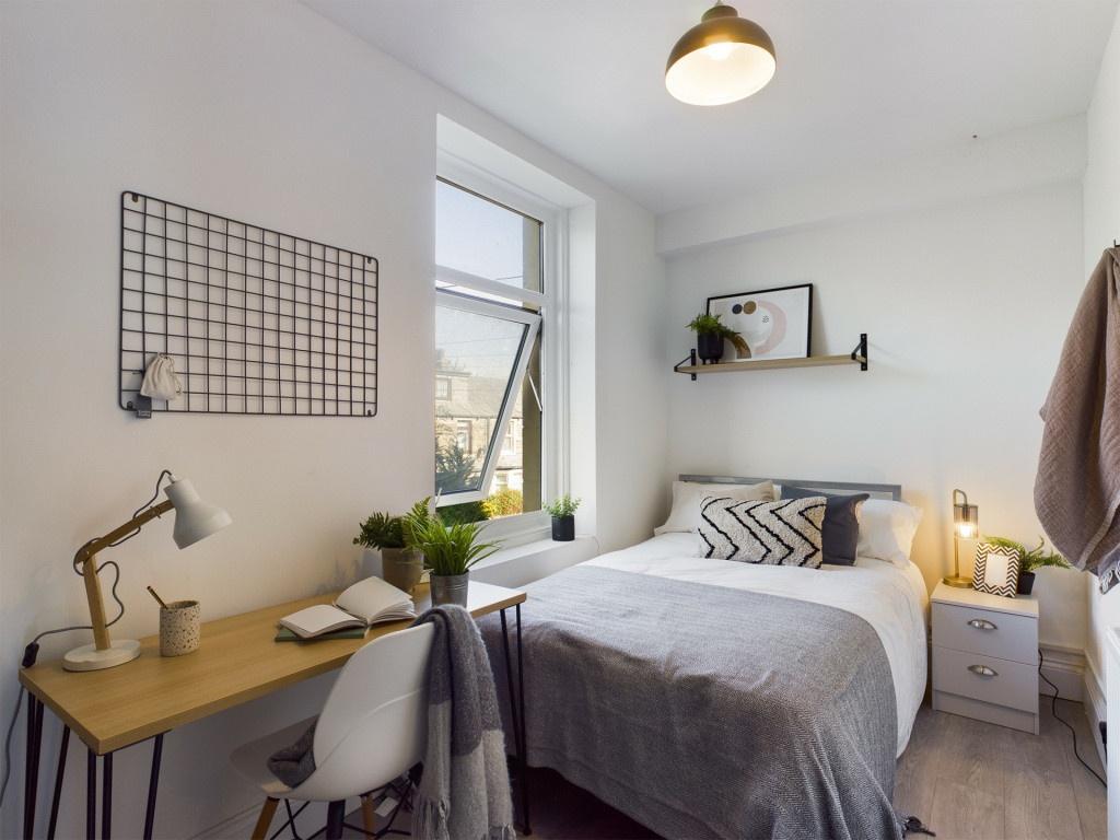 A bright and inviting bedroom featuring a cozy ...
