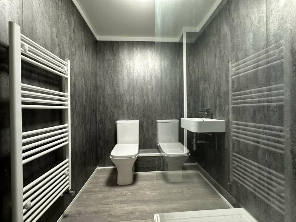 A modern, clean bathroom with a toilet and sink...