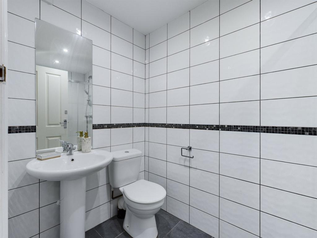 A bright and modern bathroom featuring sleek ti...