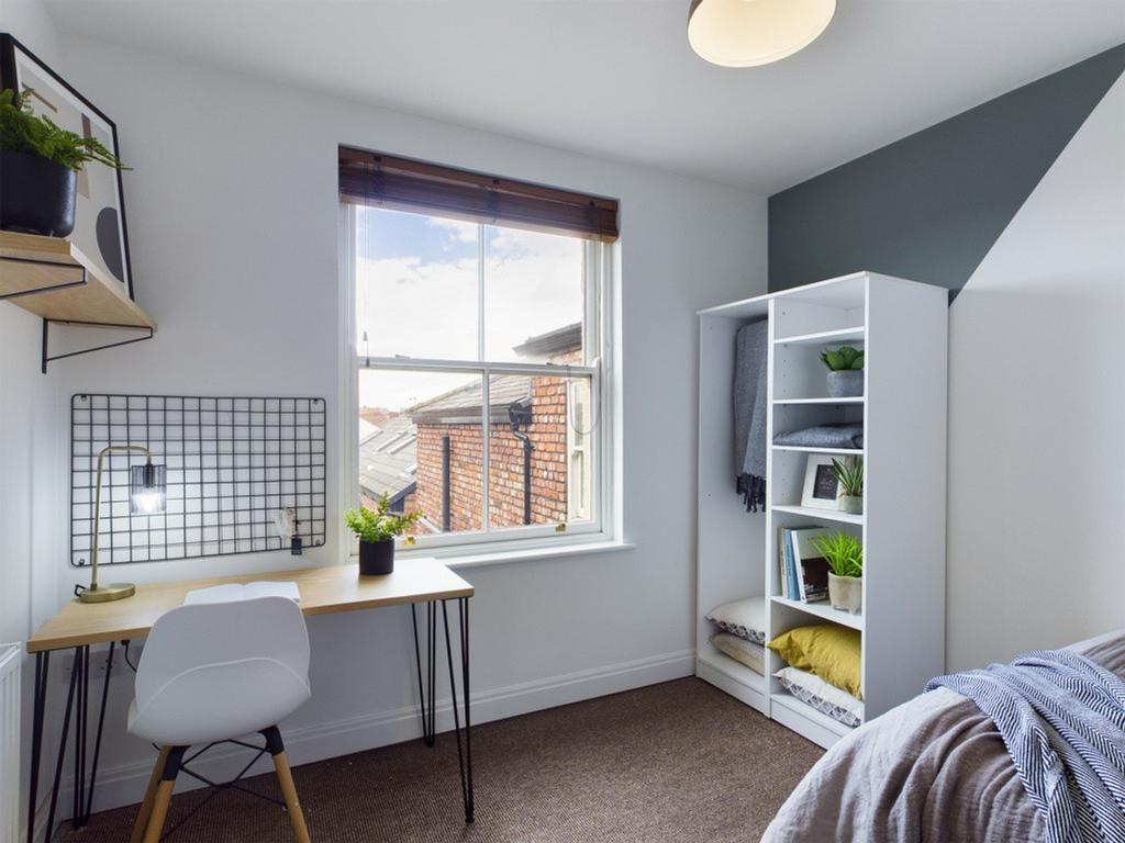 A bright and inviting double bedroom with a sty...