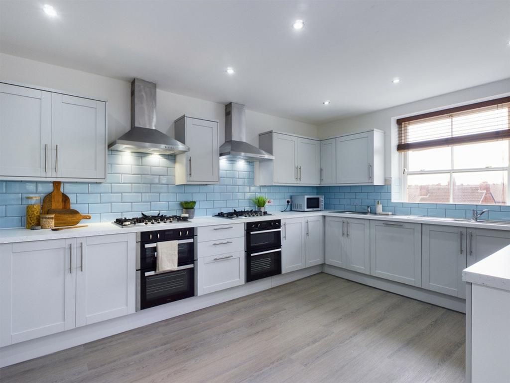 A bright and modern kitchen featuring sleek cab...
