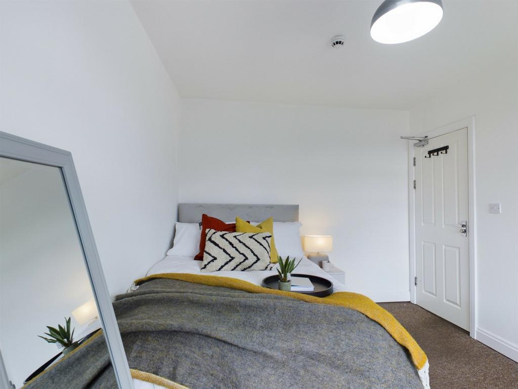 A bright and inviting double bedroom with styli...