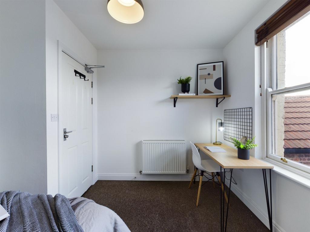 A bright and tidy double bedroom featuring a co...