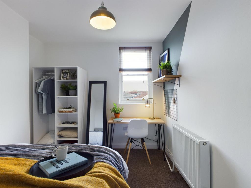 A bright and clean double bedroom with a cozy w...