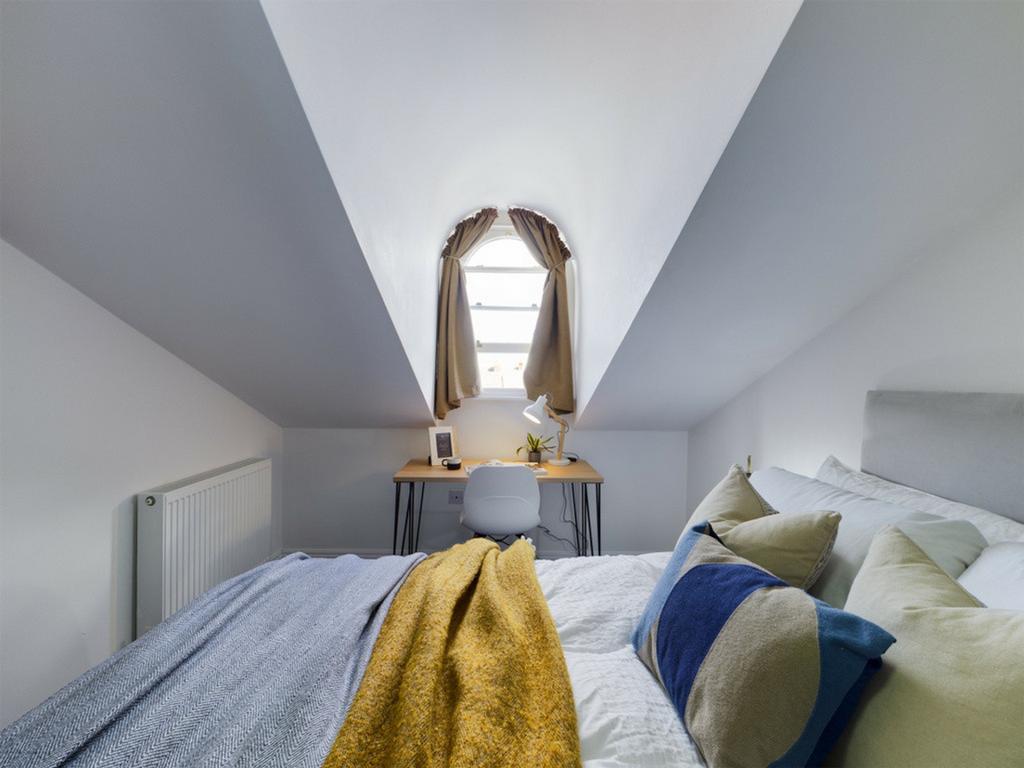 A cozy and well-lit double bedroom with a charm...