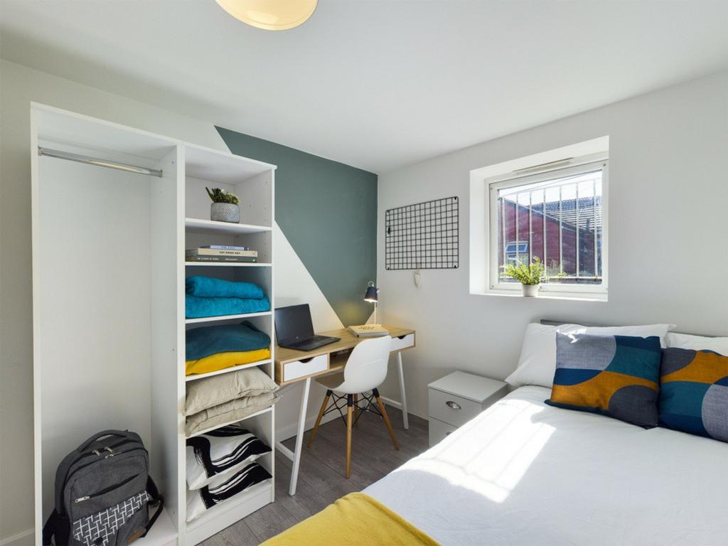 A bright and tidy double bedroom featuring a st...