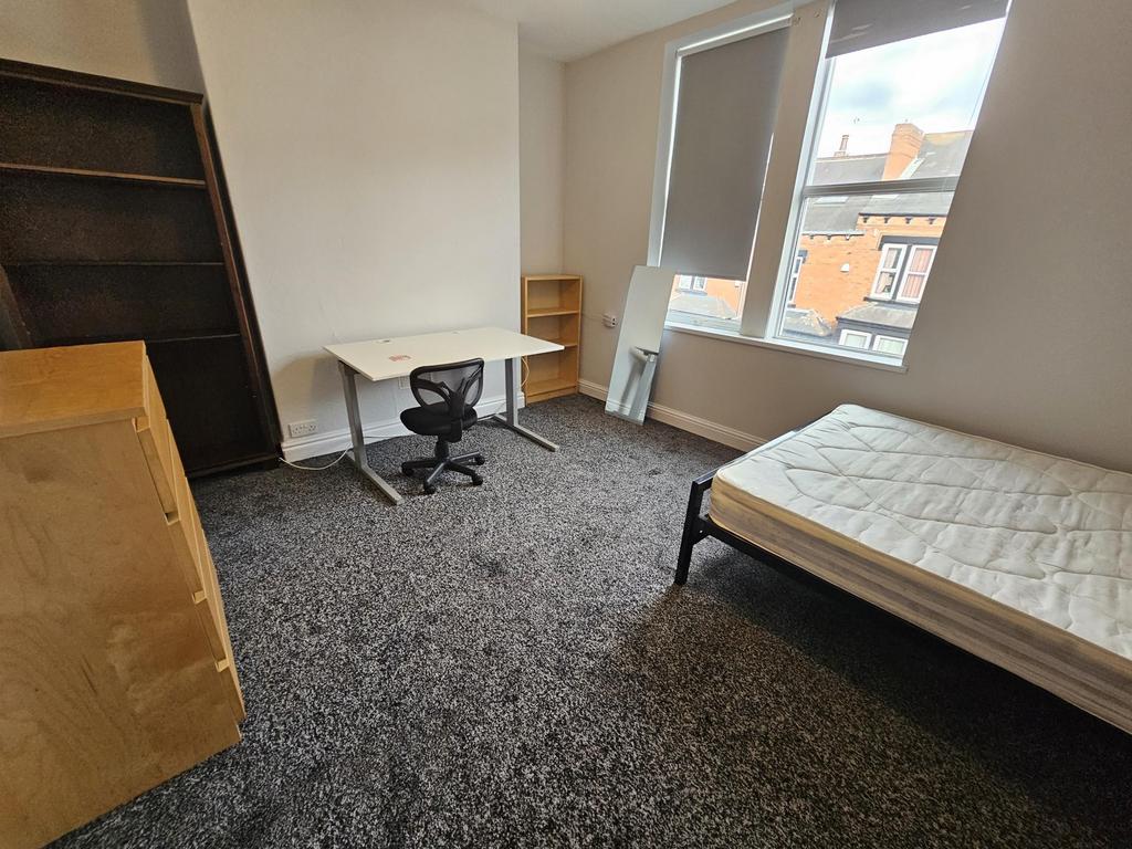 A bright and tidy bedroom featuring a single be...