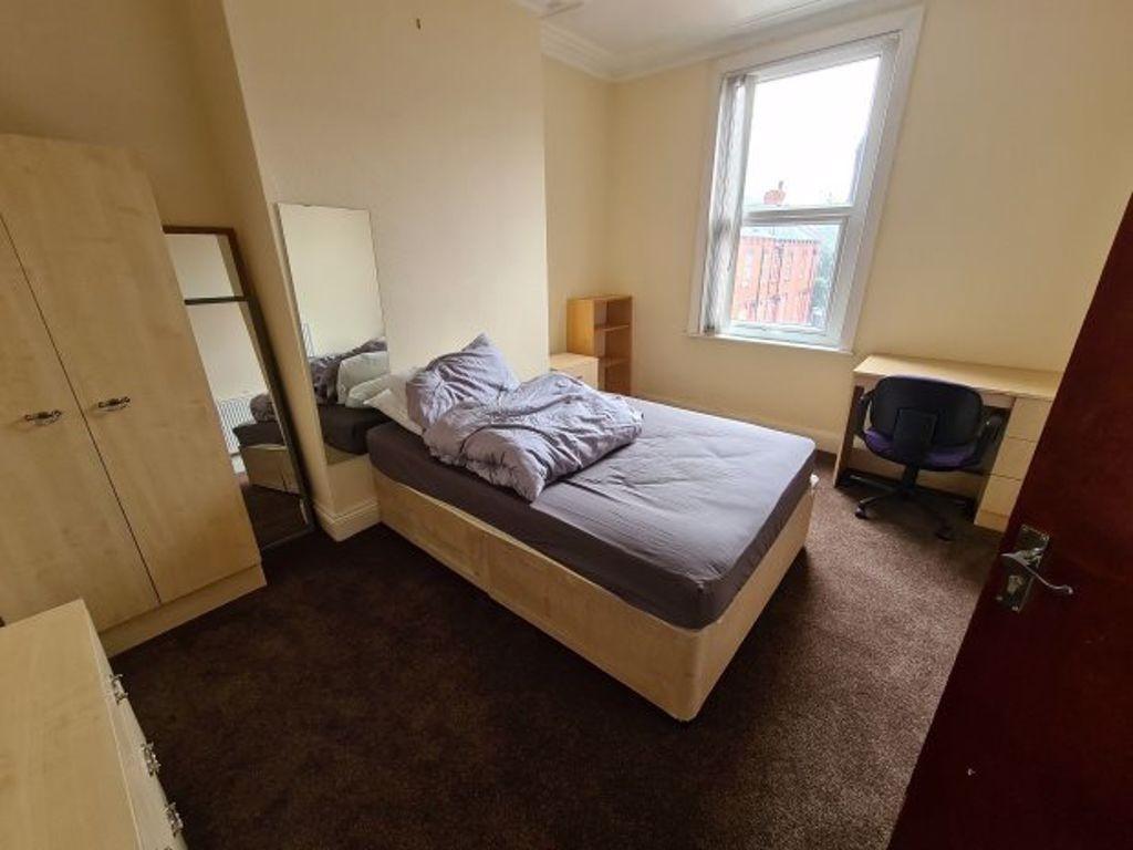 A cozy bedroom featuring a single bed with bedd...