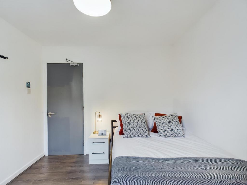 A bright and tidy double bedroom featuring a co...